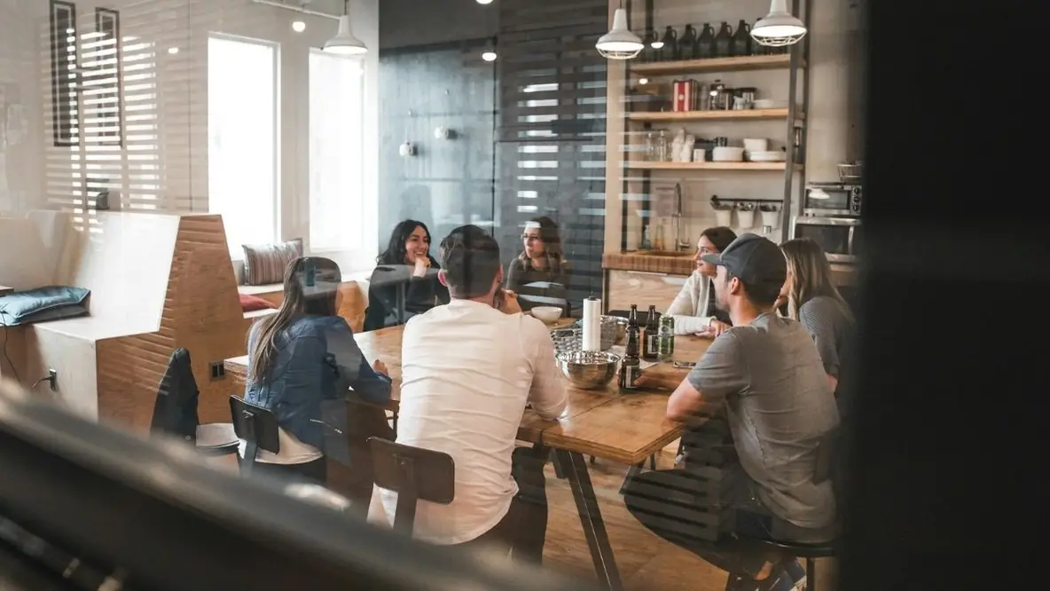 A team meeting at a long table in a cafe