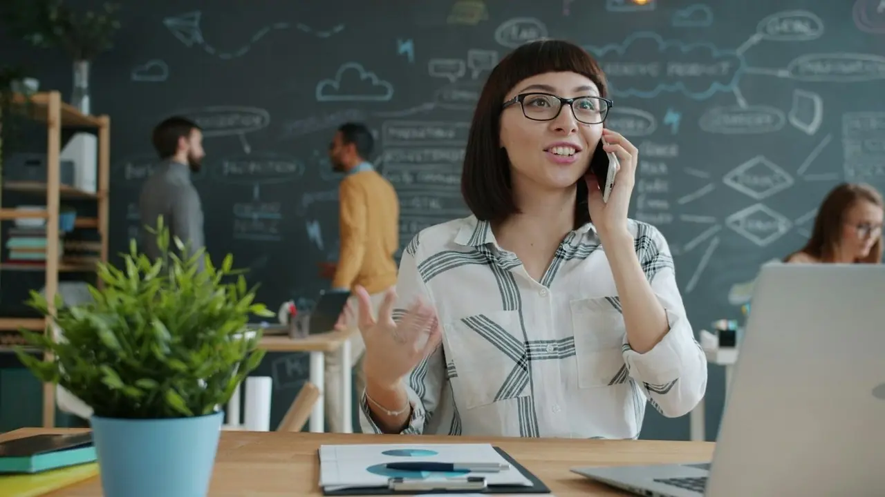 A woman on a phone call in an open office