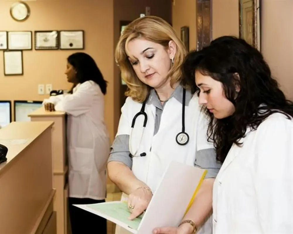 Clinic staff reviewing a chart at the front desk