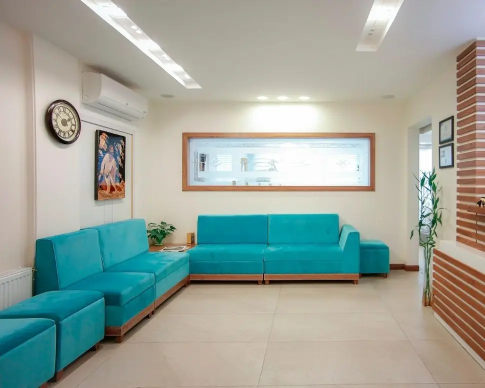 A clinic waiting room with teal sofas