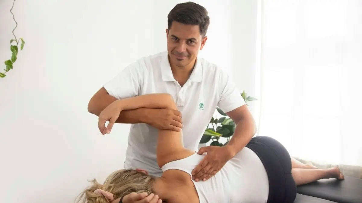 A physiotherapist treating a patient on a table
