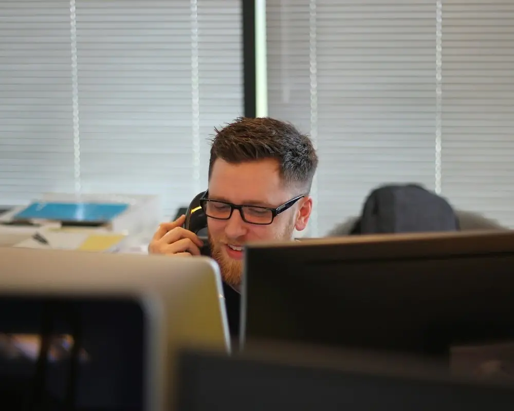 A man on a call behind his monitors