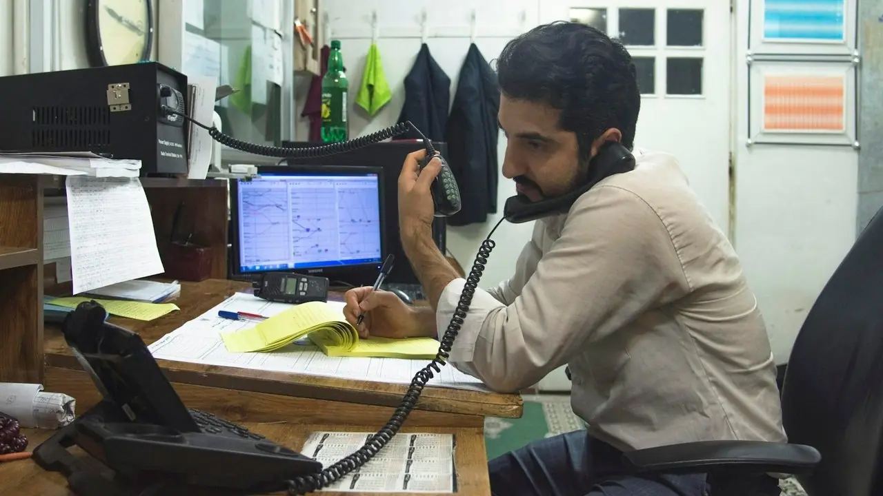 A man taking a call at his desk