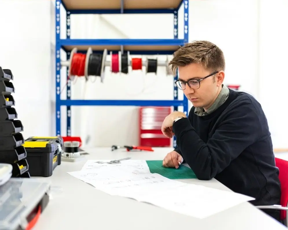 An engineer at a workbench with cable reels