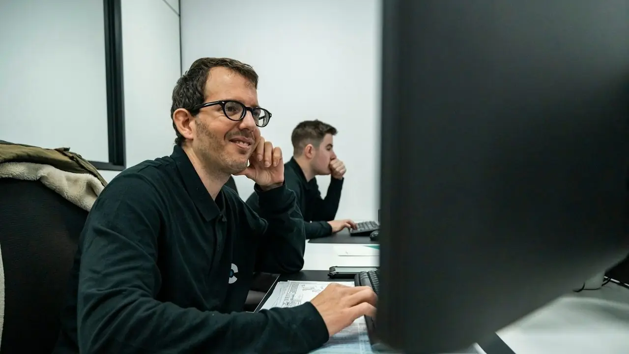 An engineer smiling at his workstation