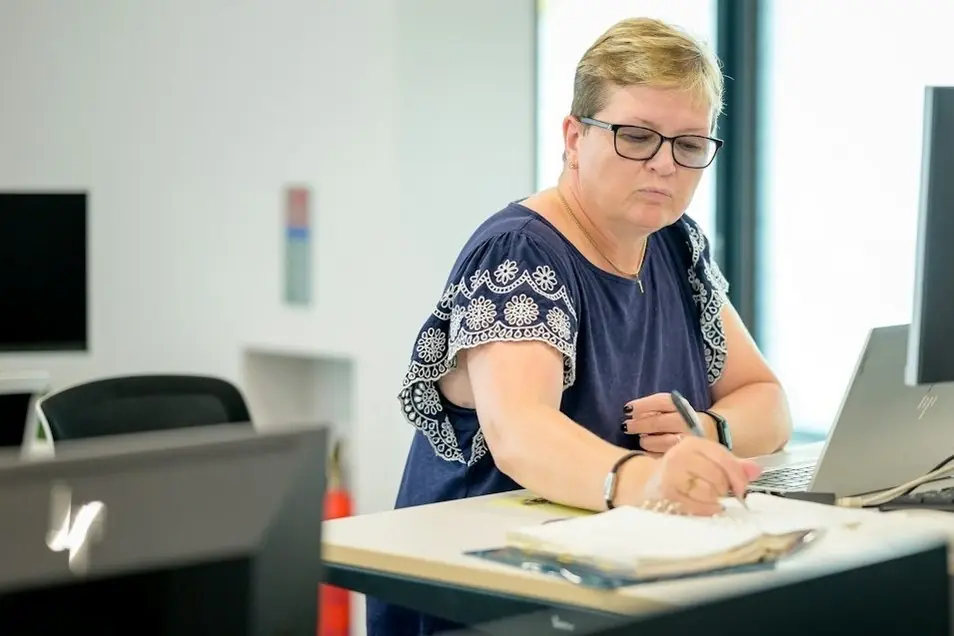 A woman filling in paperwork at her desk
