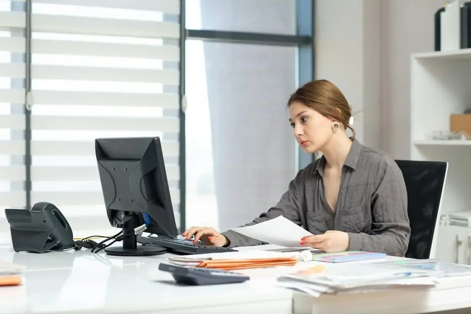 A woman checking documents at her computer