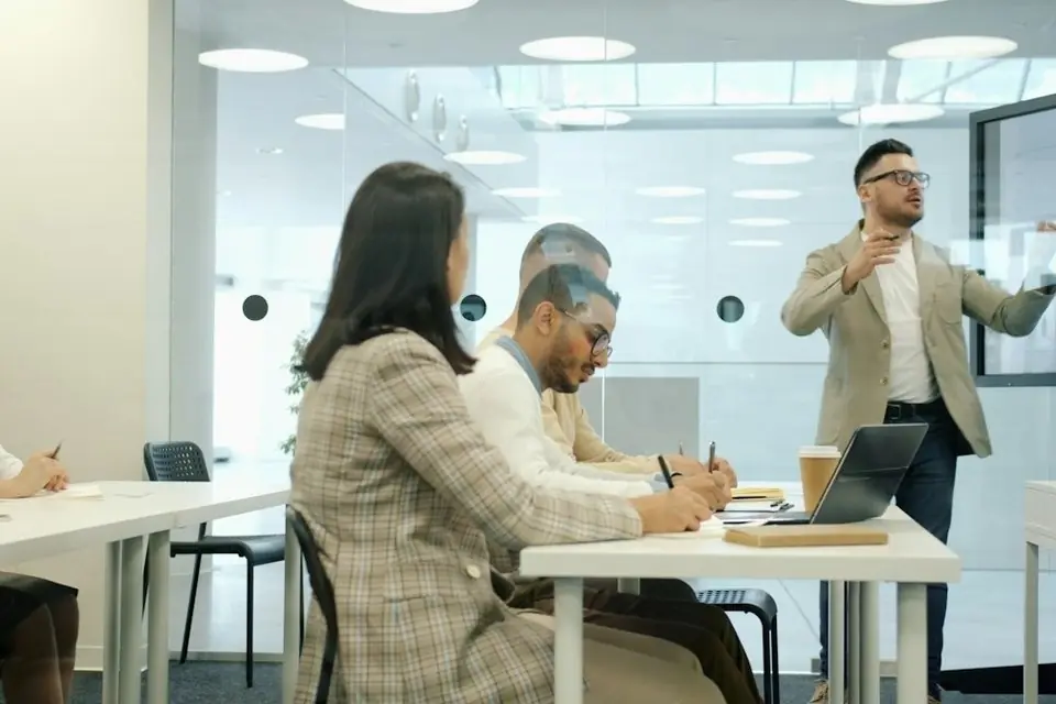 A trainer presenting to a team in a bright office