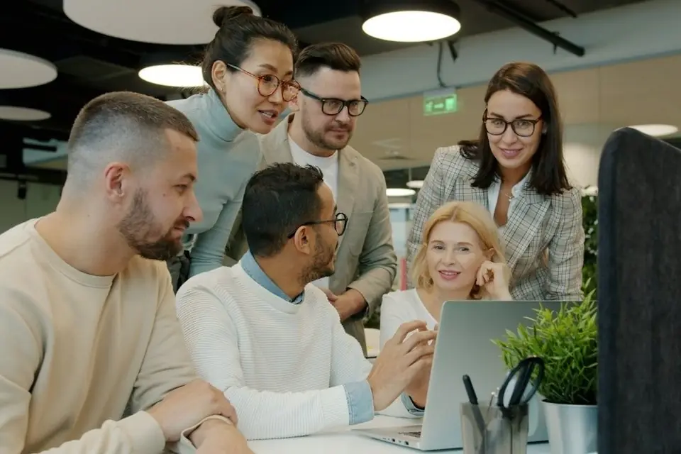 Colleagues gathered around a laptop