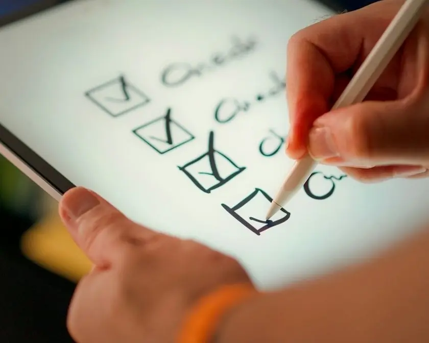 A hand ticking boxes on a checklist