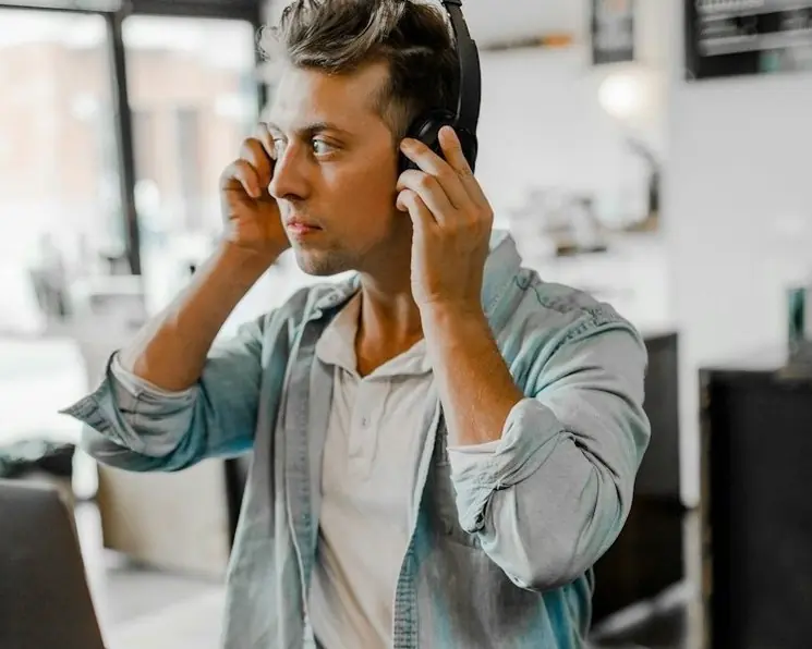 A man in headphones listening closely