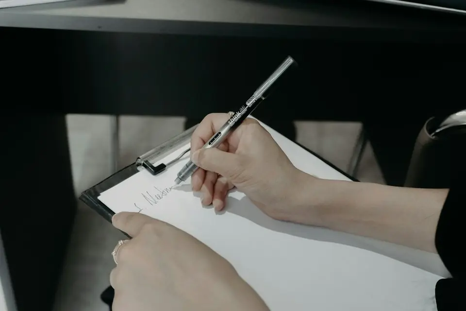 A person writing on a clipboard