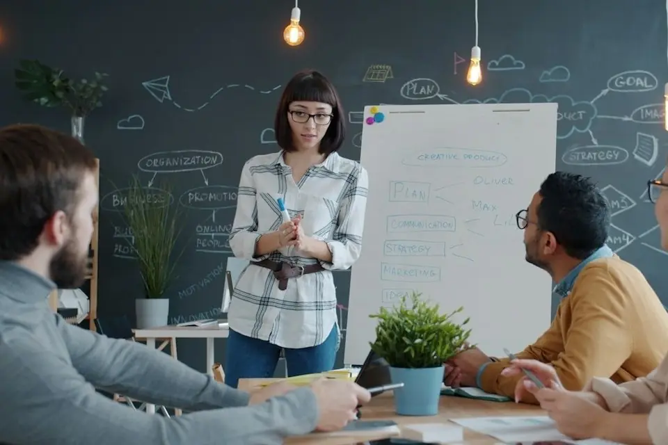 A trainer leading a team session at a whiteboard