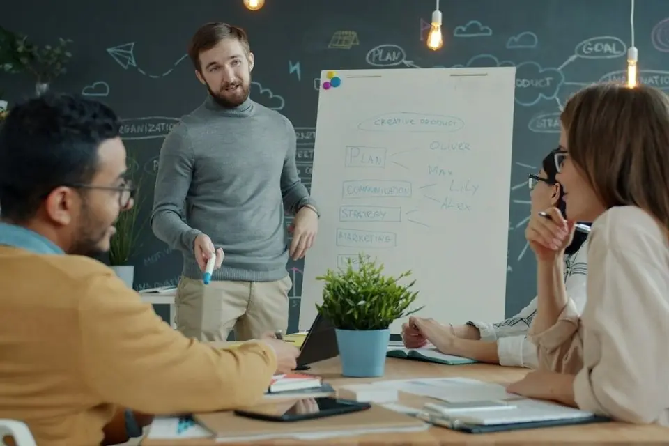 A team meeting around a whiteboard