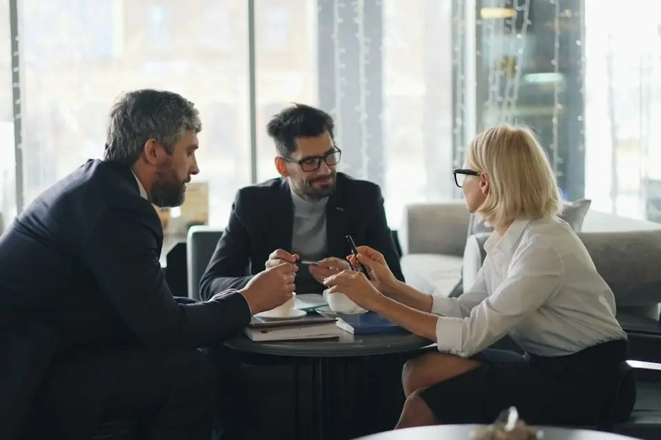 Three colleagues meeting around a table