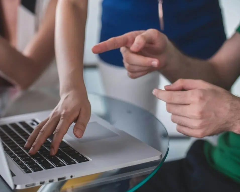 Two people troubleshooting together at a laptop