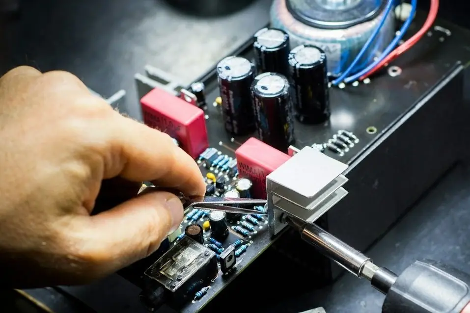 A hand working on a circuit board