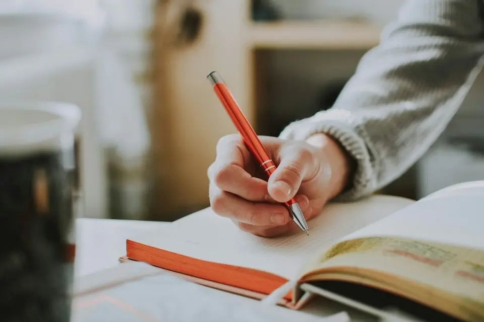A hand writing notes in a notebook