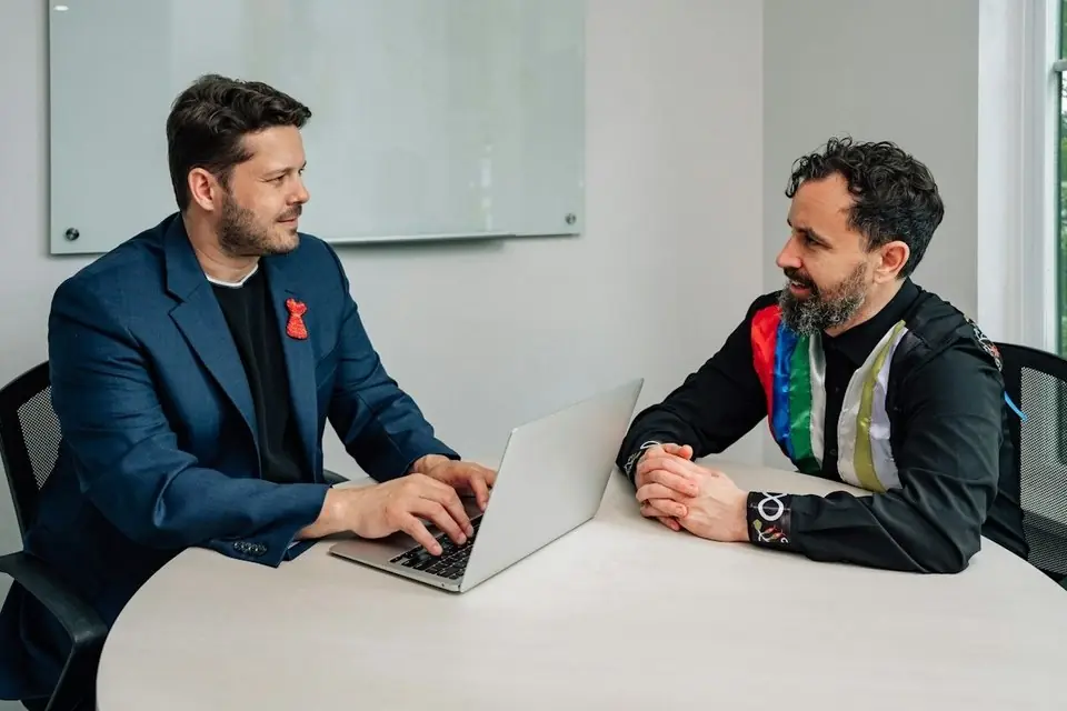 Two men discussing an issue at a laptop